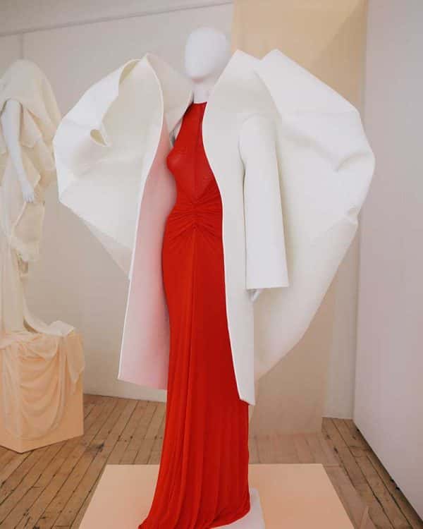 Amy Ollett - Image of a mannequin wearing a red dress and a white coat