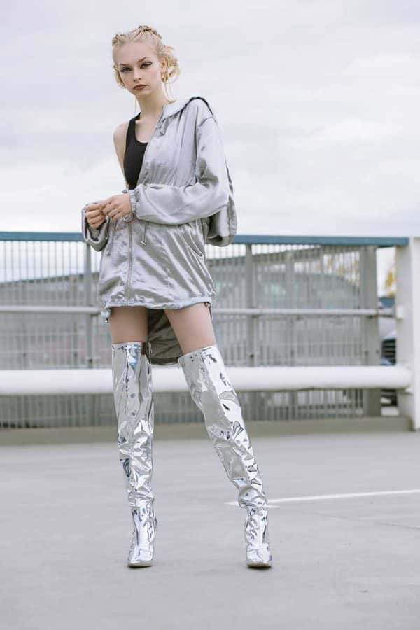 Beth Poulter - Image of a model standing in an urban landscape wearing silver clothing