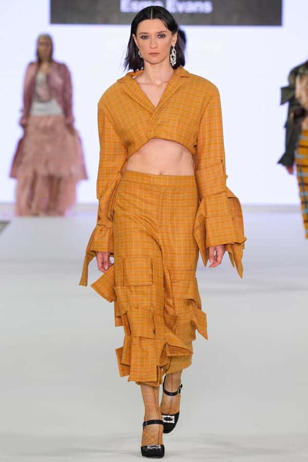 Esme Evans - Image of a model wearing a yellow garment on a catwalk