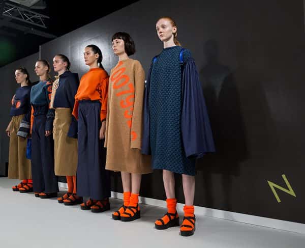 Daisy Clarke - Image of models on the catwalk wearing navy and orange designs