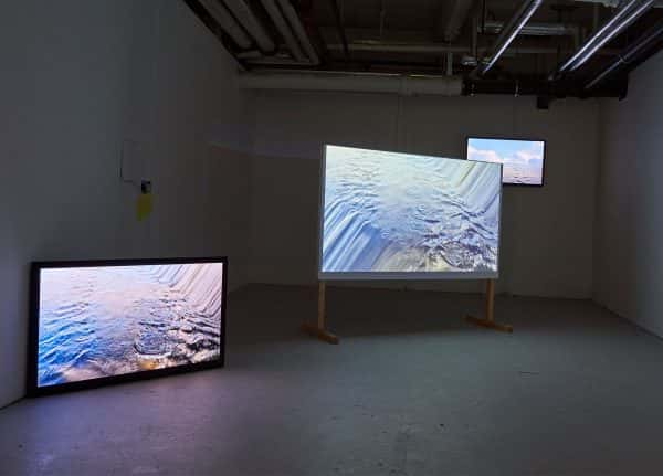  - Image of 3 screens in a gallery space with water on the screen