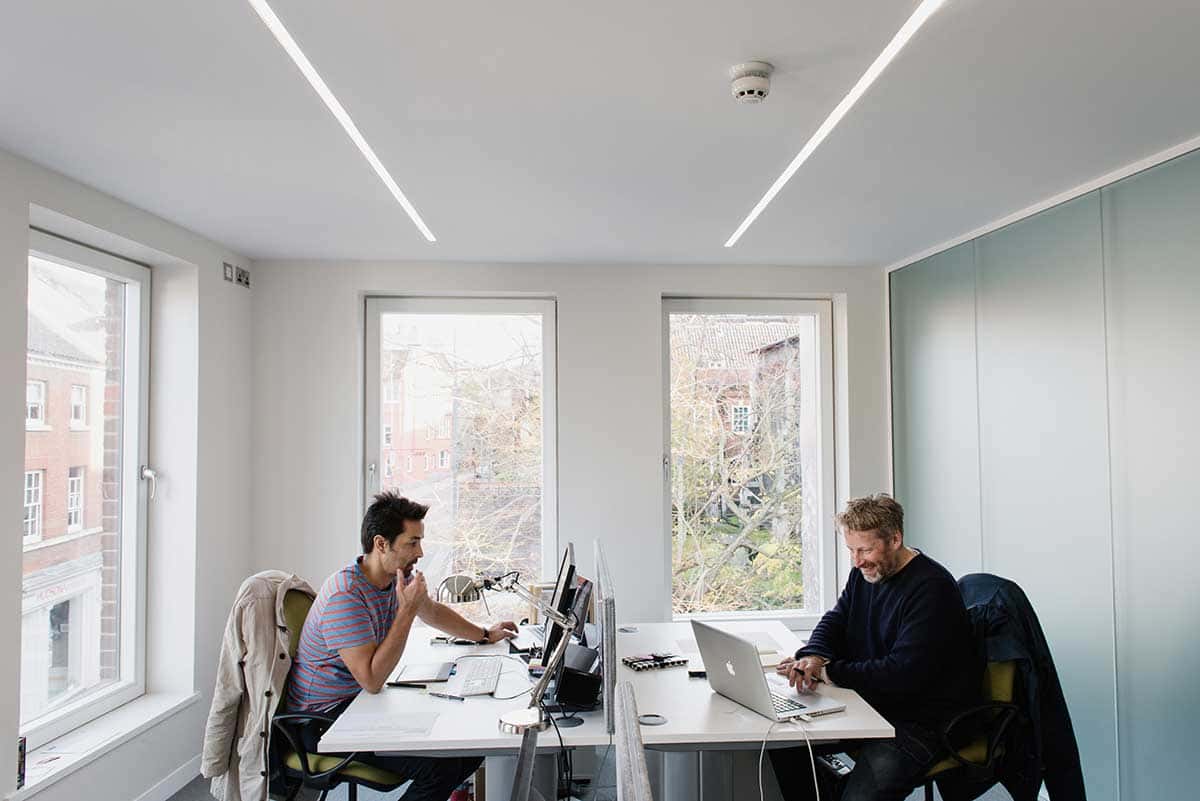 Men in agency doing work in front of computers