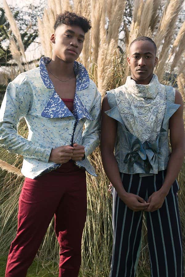 Sophie Chittock - Image of two male models wearing extravagant clothing and looking straight to the camera