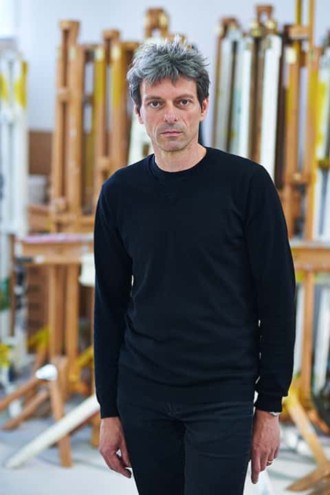 photo of senior lecturer Professor Krzysztof Fijalkowski standing with arms by side and looking at camera with grey short hair and a long sleeved black top