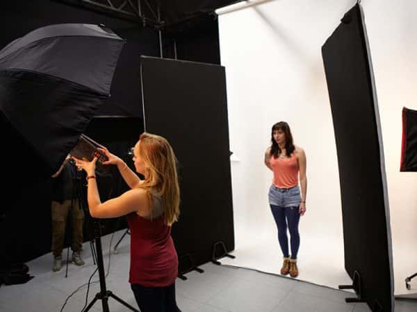  - Image of two students taking a photograoh in a photography studio