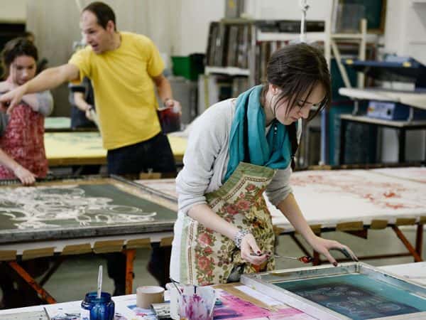  - Image of a student works on a screen in a printing studio