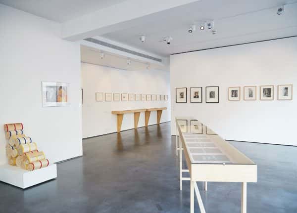 East GalleryNUA - Image of a vitrine and hanging frames pictures in an interior white gallery space