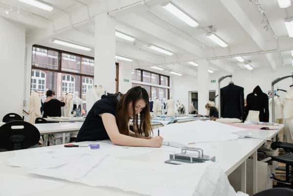  - Photograph of three students at work in NUA's fashion studios