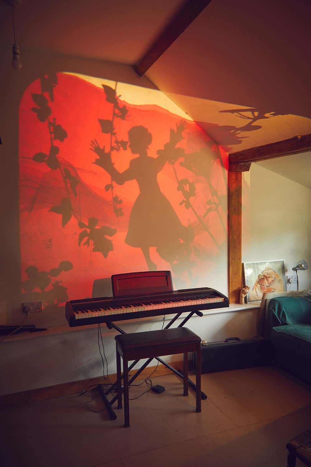 Professor Suzie Hanna's studio showing an animation of a girl with trees on a wall by a piano and stool