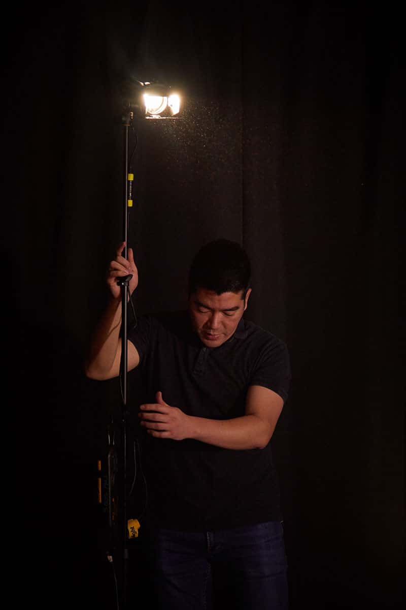 Roter Su, film Lecturer setting up a light on set