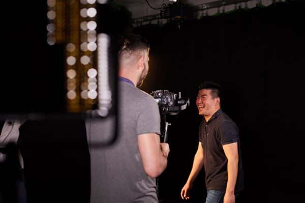 Roter Su - Roter Su, Lecturer in Film at Norwich University of the Arts stands by a light on a film set laughing whilst talking to camera operator