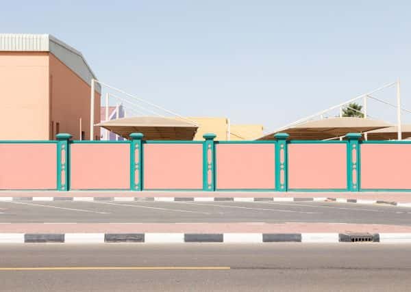 Lara Chandler - Photo of a wall by BA Photography student Lara Chandler. The wall is pink with green stripes and located next to a road in Dubai.