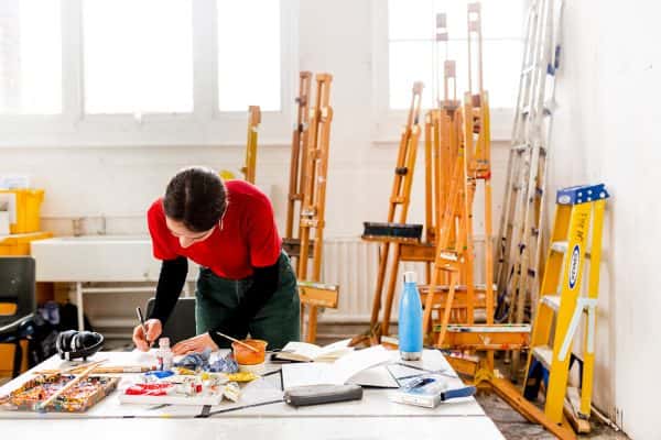 - Student working in the Norwich University of the Arts painting studios, painting with easels behind