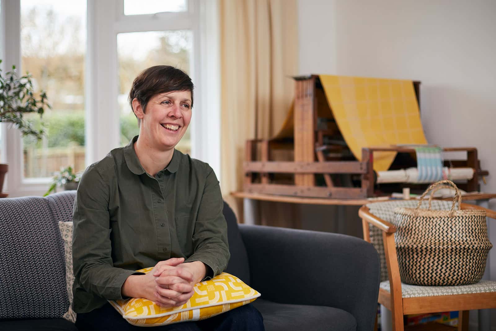 Kate Farley, Course Leader of BA Fashion and BA Textile Design sat in her home-studio in front of a loom