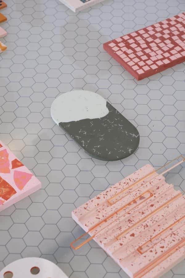 Victoria Paulley - A grey table with individual terrazzo pieces in pink, red, coral and grey in different shapes placed apart from each other