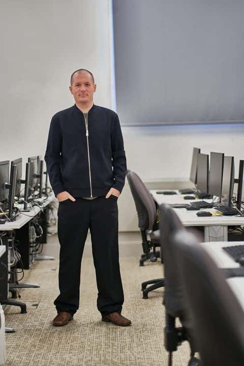 BA Games Art and Design Lecturer Jack Allen standing in computer lab at Norwich University of the Arts
