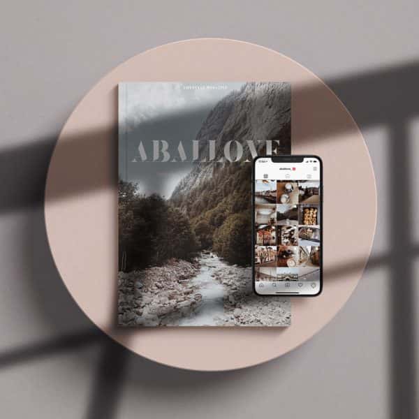 Aballone - Aballone magazine, designed and launched by BA Design for Publishing students Toby McLaren and Hannah Roadknight. A magazine laid on a pink background. A mountainscape is on the front cover, with the word 'Aballone'. On top of the magazine is an iPhone open on the Aballone instagram feed.