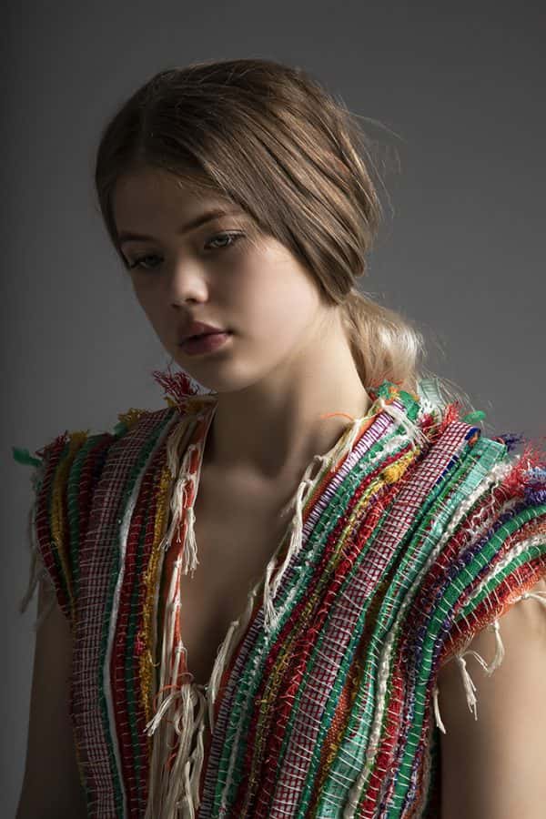 Romilie Fraser - The model wears a loose-weave tie-front vest which looks to be made from strips of reclaimed fabric and string, to create a varied texture.